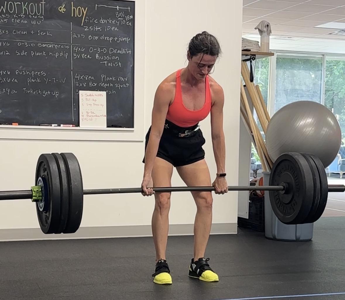 Woman performing a heavy deadlift at The Perfect Squat gym