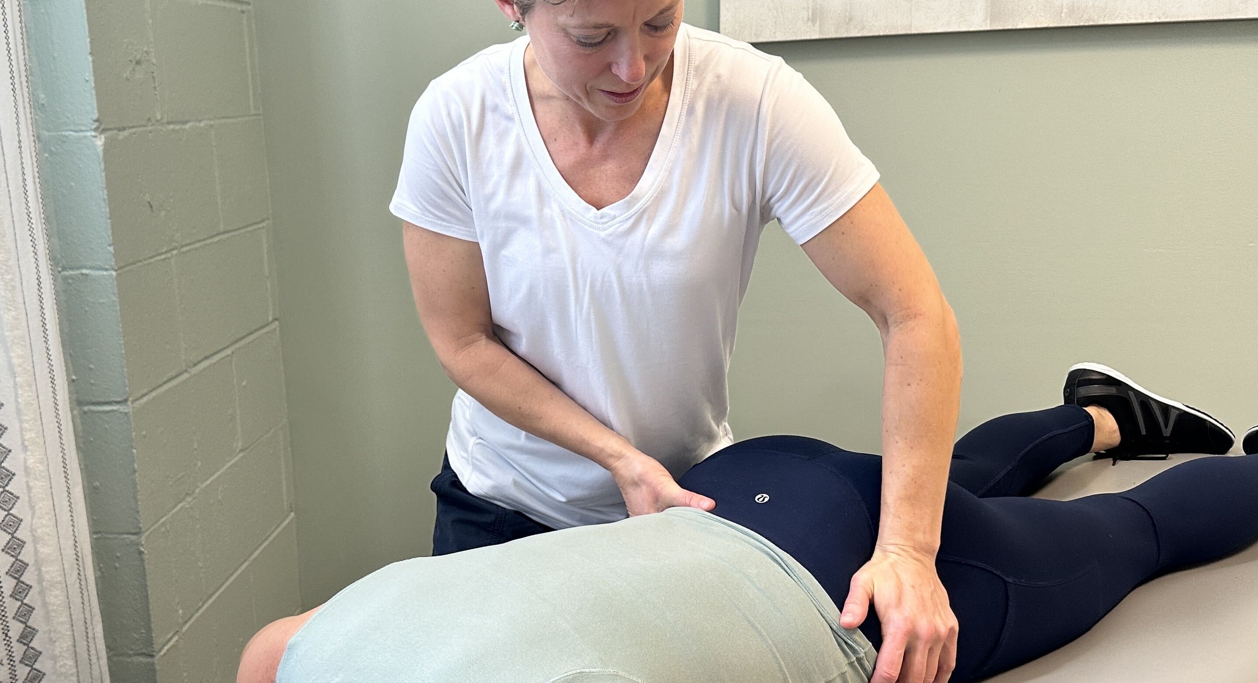 Physical therapist performing a hands-on evaluation and treatment on a patient at The Perfect Squat in Indianapolis