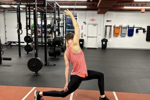 Athlete performing an overhead lunge on the indoor sprint track at The Perfect Squat in Indianapolis