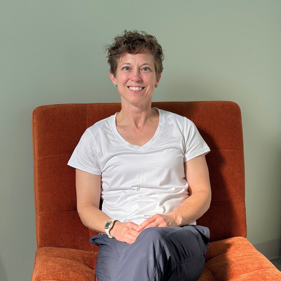 A Perfect Squat team member seated in a burnt-orange chair