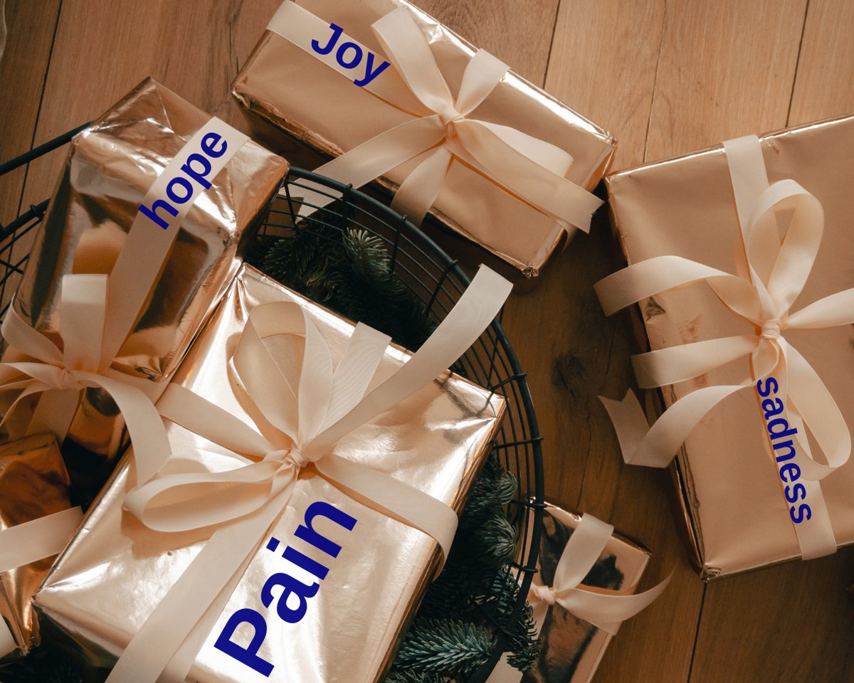Gold-wrapped gift boxes with ribbons labeled Pain, Joy, hope and sadness